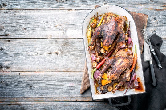 Traditional barbecue pheasant with vegetable and game sauce as top view in a stewpot with copy space left