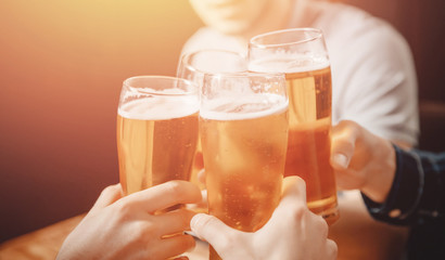 Cheerful and happy old friends are drinking draft beer at pub bar. Friendship concept