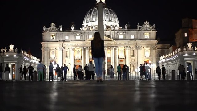 Many tourists are near the Vatican City, enjoying beautiful architecture and photographing at night. Panoramic view on St. Peter's Basilica.