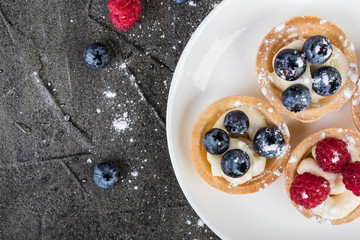 tartlets or cake with cream and  berries. Pastry dessert. Top view