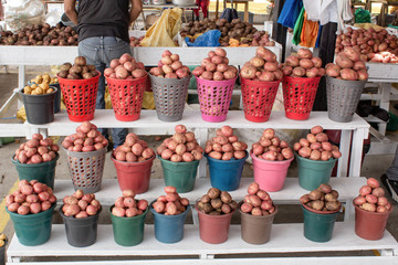 Selling potatoes on the market. Potatoes are packaged in buckets. Quito. Ecuador.