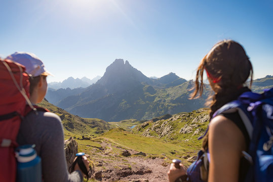 Walkers admire the view of Pic du Midi d'Ossau from the top of Col d'Ayous on the GR10 trekking route, Pyrenees Atlantiques, France