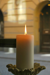 Bonita estampa de una vela sobre un ventanal que da a la calle solitaria en una tarde fria