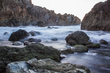 rocky beach with moss and black sand. Volcano stones in a natural pool at Tenerife North 