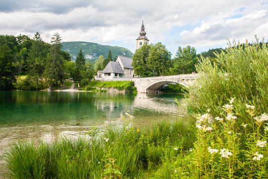 The bridge and church in the lakeside village of Ribcev Laz, Lake Bohinj, Slovenia