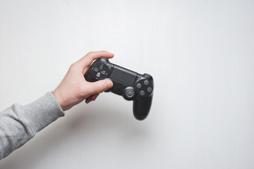 Hand hold new joystick isolated. Gamer play game with gamepad controller. Gaming man holding simulator joypad. Person with keypad joystic in arms. Sleeve hands hold toy equipment. Modern manipulator.