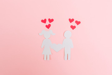 The girl and the guy from paper, a loving couple on a pink background