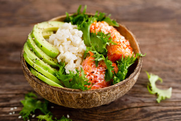 Hawaiian poke coconut bowl with grilled salmon fish, rice and avocado. Healthy food - Powered by Adobe