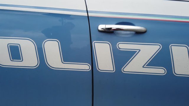 Slow overview of the white writing Italian police on the profile of the service blue car