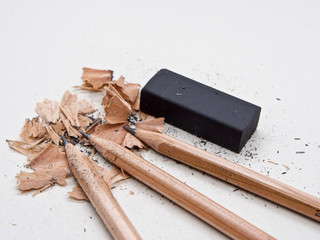 Pencils and black eraser, debris on grey sketch notepad background
