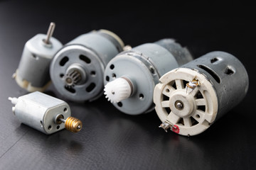 Small electric engine on a wooden dark table. Electric drive for small home appliances.