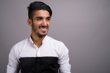 Obraz premium Young handsome Persian businessman against gray background
