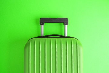 Luggage on green background minimalistic vacation concept.