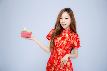 Happy Chinese New Year beautiful portrait young asian woman holding red gift box isolated on white background, girl smile and showing present purchase, holiday concept.