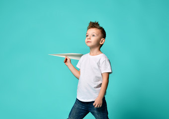 Little boy looks up in sky watches something in sky and holds a paper plane. new begining.