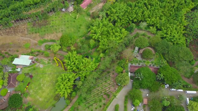 AERIAL: tilting up to reveal the terrain further out towards the horizon, over the precious Panaca park in Quidio, Colombia, that's been surrounded by coffee plantations.