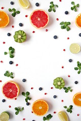 Colorful food pattern made of pomegranate, kiwi, valerian, blueberries, pomegranate, lime, lemon and orange. Top view with copy space.