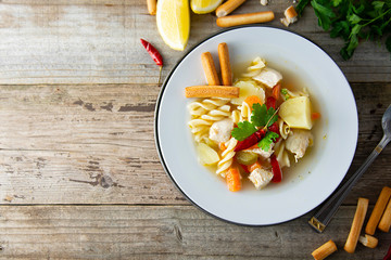 Chicken soup with noodles and vegetables, rustic wooden background. Healthy homemade food. copy space.