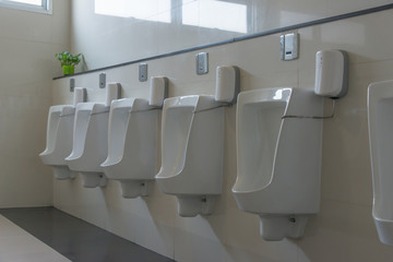 Row of white ceramic urinal chamber pot interior design men public toilet or restroom