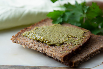 Whole grain bread with fresh basil pesto. close up. Healthy food snack.