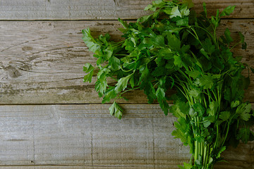 Parsley on a cutting board, on a wooden brown table. Fresh greens