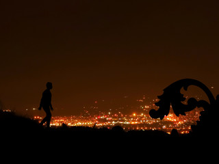 Obraz na płótnie Canvas Boy Silhouette against the Background of a Night Cityscape