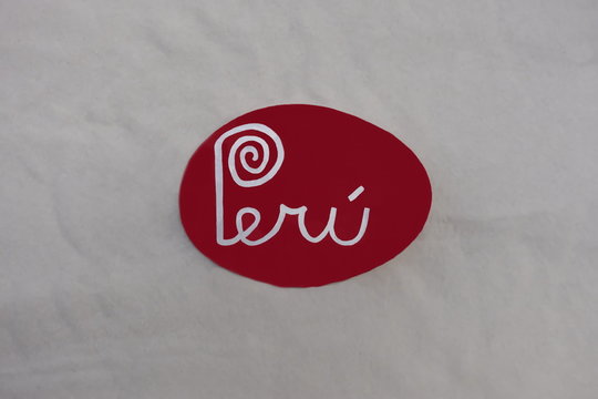 Peru, south american country text carved and painted on a stone over white sand