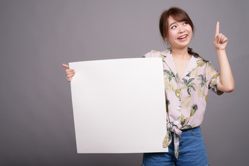 Asian woman holding empty white board with copyspace