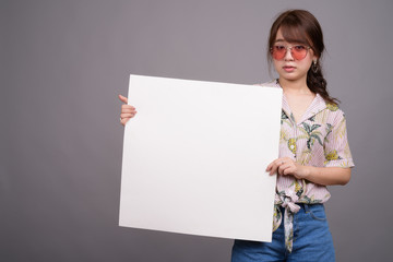 Asian woman holding empty white board with copyspace