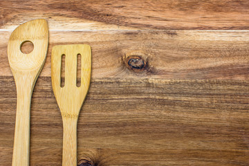 Wooden kitchen tools on wooden background, top view