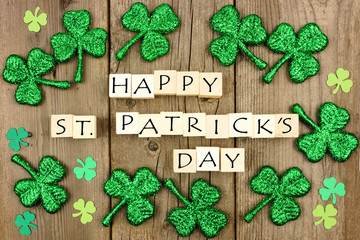 Happy St Patricks Day wooden blocks with shamrock decor on a rustic wood background