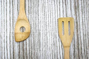 Wooden kitchen tools on wooden background, top view