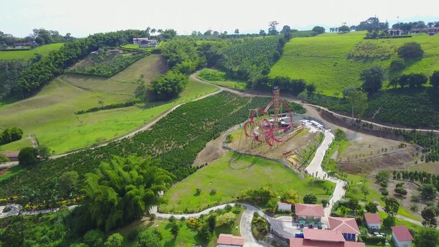 AERIAL: pushing past the water rafting course and roller coaster ride in the Parque del Cafe in Quidio, Colombia, that's been surrounded by coffee plantations.
