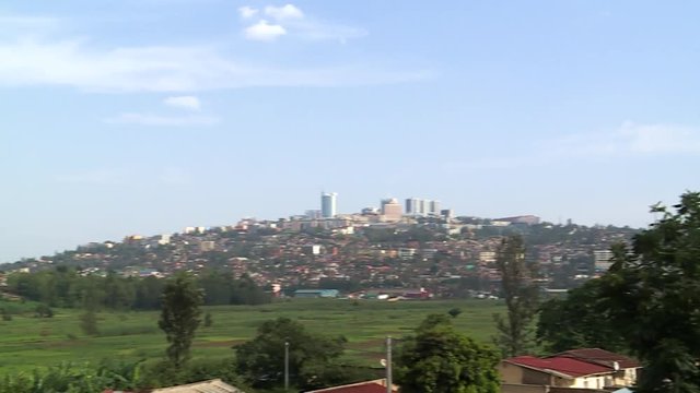 Fast right pan from a hill with houses in the suburbs of Kigali towards the city center skyline, Rwanda.