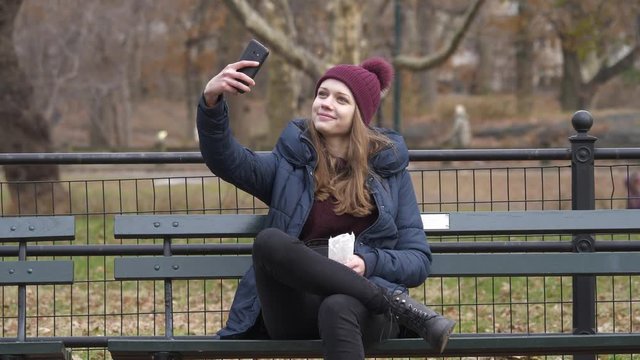 Young woman sits on a bench in Central Park New York