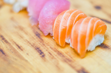 Closeup of chef hands preparing japanese food. Japanese chef making sushi at restaurant. Young chef serving traditional japanese sushi served on a black stone plate.