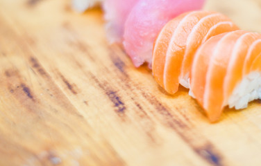 Closeup of chef hands preparing japanese food. Japanese chef making sushi at restaurant. Young chef serving traditional japanese sushi served on a black stone plate.