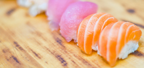 Closeup of chef hands preparing japanese food. Japanese chef making sushi at restaurant. Young chef serving traditional japanese sushi served on a black stone plate.