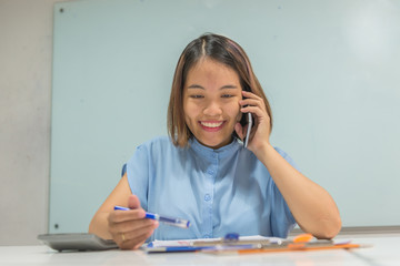 Smiling business employee read the report and answer phonecall