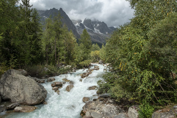 Fototapeta na wymiar Fast flowing river flowing from Les Grands Jorasses, Italy