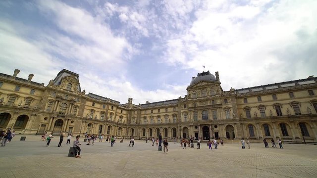 Tourists walk in front of the Louvre in Paris, France. The Louvre Museum is one of the largest and most visited art museum in the world. Timelapse video