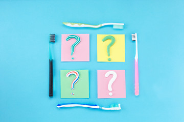 Symbol of question mark from toothpaste and toothbrush on blue background,