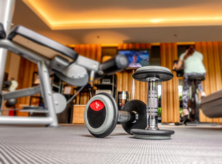 Dumbbell in fitness room with blurred people exercise in background