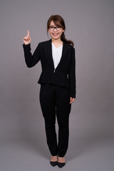 Full length portrait of young Asian businesswoman standing