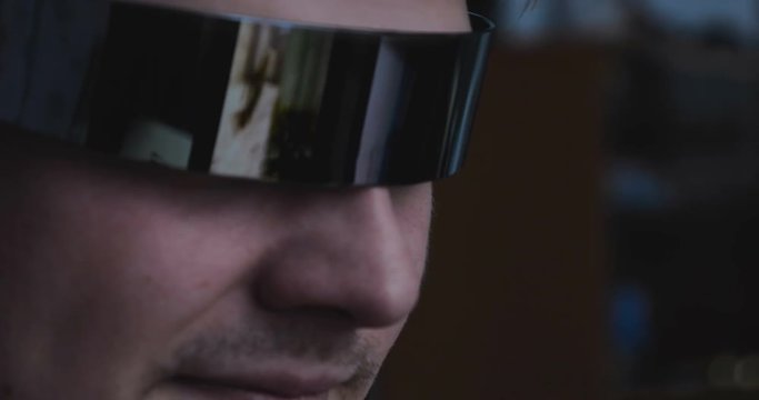 The guy (male) gamer in a tracksuit and game glasses. In the reflection you can see the game guy completely immersed. Concept of: 3D, Fully immersed in the game, Reflections, Dependence.