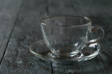 Empty glass Cup with saucer on wooden rustic wooden table.