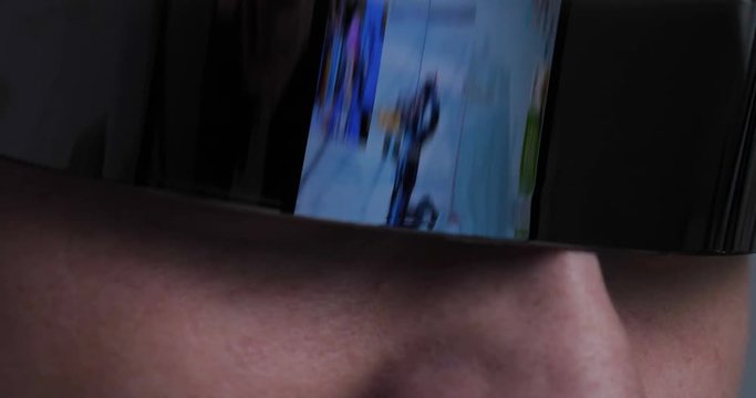 The guy (male) gamer in a tracksuit and game glasses. In the reflection you can see the game guy completely immersed. Concept of: 3D, Fully immersed in the game, Reflections, Dependence.