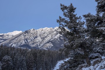 Early morning sun lighting up the snow covered mountains next to the town of Banff, Alberta, Canada.