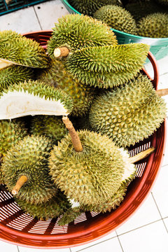 A large basket of Southeast Asian durian fruit for sale at a market.