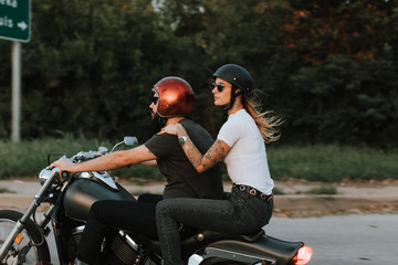 Biker couple riding down the road in the sunset